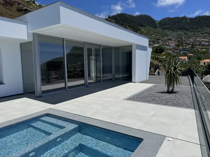 The terrace and the pool in front of the glass doors